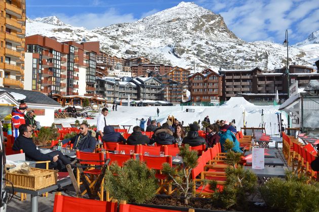 Onderaan de piste, in het dorp, genieten van een chocomelk in de zon