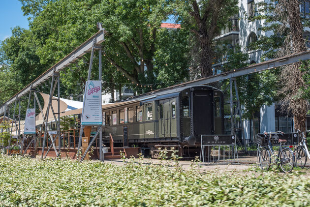 Aan de overkant van de LocHal kun je dineren in deze oude treinstellen