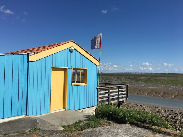 De gekleurde oesterwoningen op Ile d`Oleron met op de achtergrond de lange brug