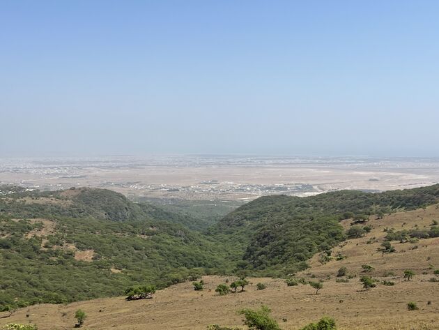 Uitzicht vanuit The View, in de verte Salalah en altijd weer de eeuwige mist