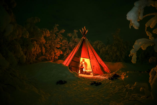 Opwarmen in een tipi tijdens het sneeuwschoenwandelen